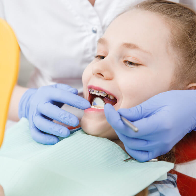 Girl having her teeth examined by a dentist