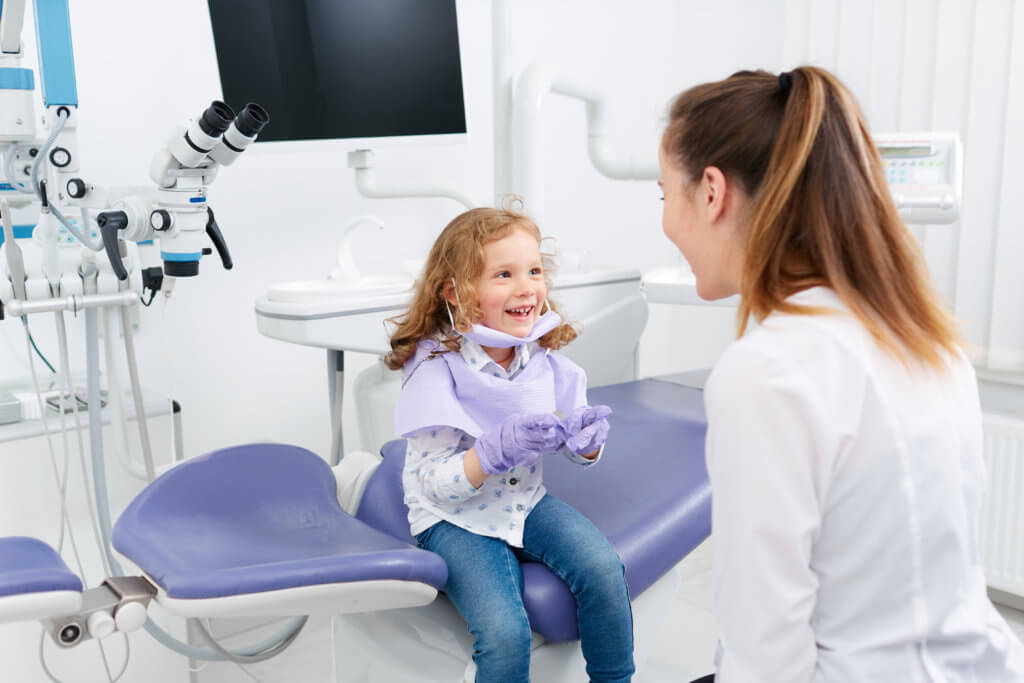 child sits on dentist chair
